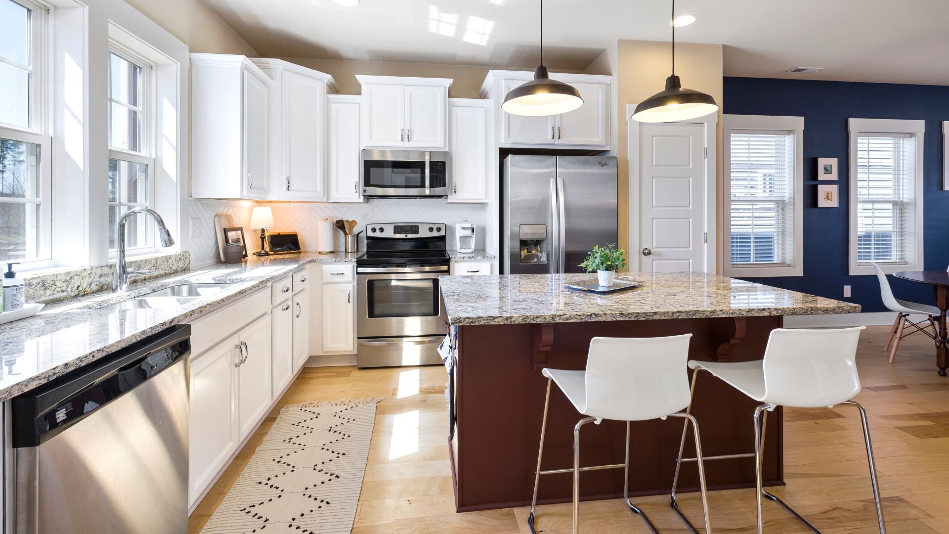 Modern kitchen with white cabinets, granite counters, and kitchen island